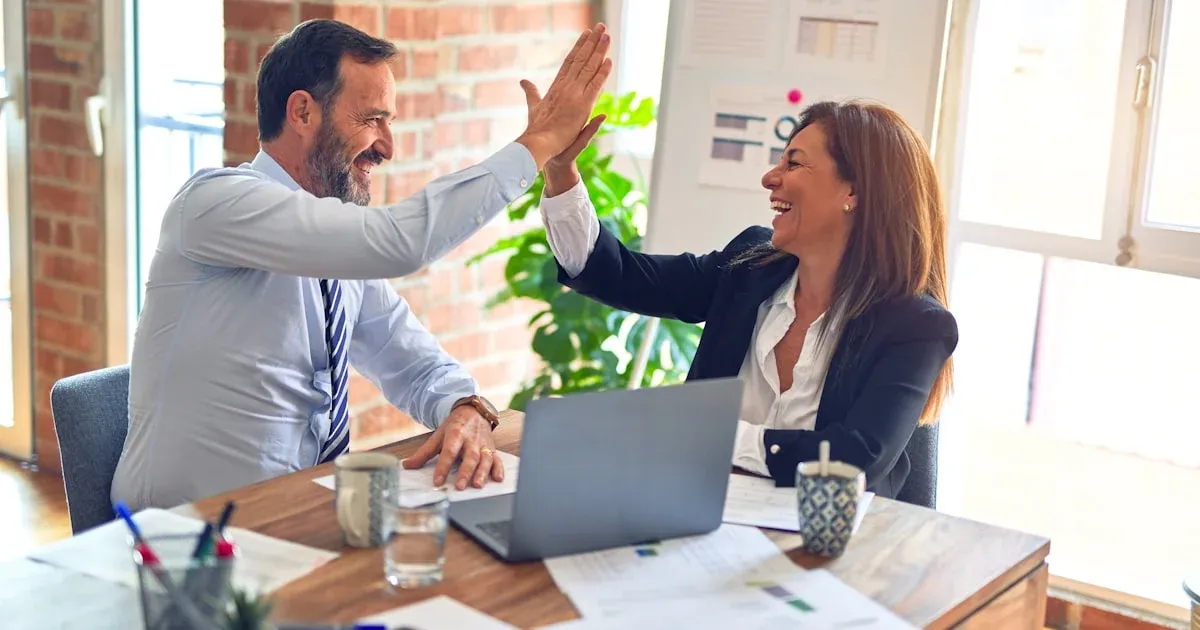 Dos profesionales revisando resultados de campañas publicitarias en una reunión de cliente en una oficina moderna