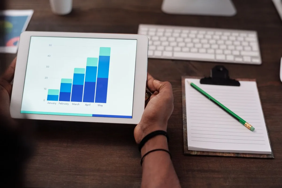Profesional de marketing revisando gráficos de rendimiento de campañas publicitarias en una tablet