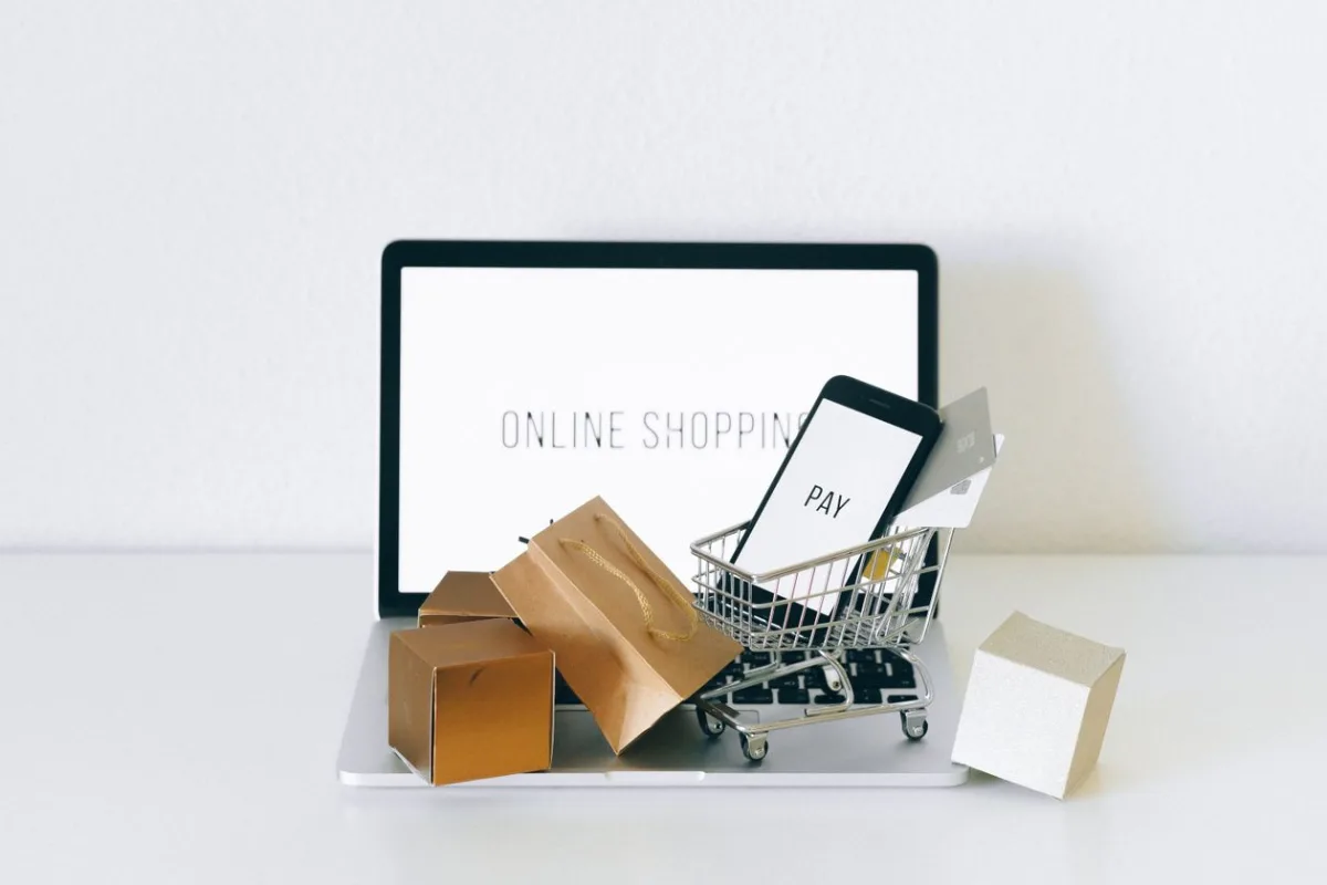 Panier miniature avec des colis sur un ordinateur portable affichant une boutique en ligne