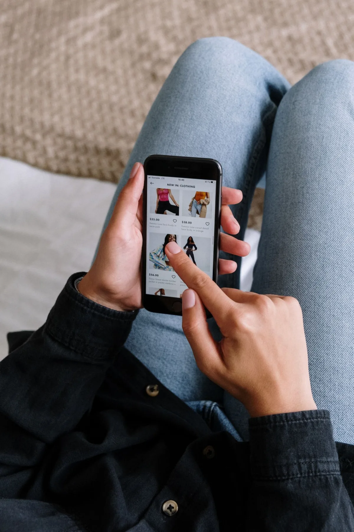 Utilisatrice achetant en ligne depuis son smartphone sur le canapé, optimisant l'expérience de checkout mobile